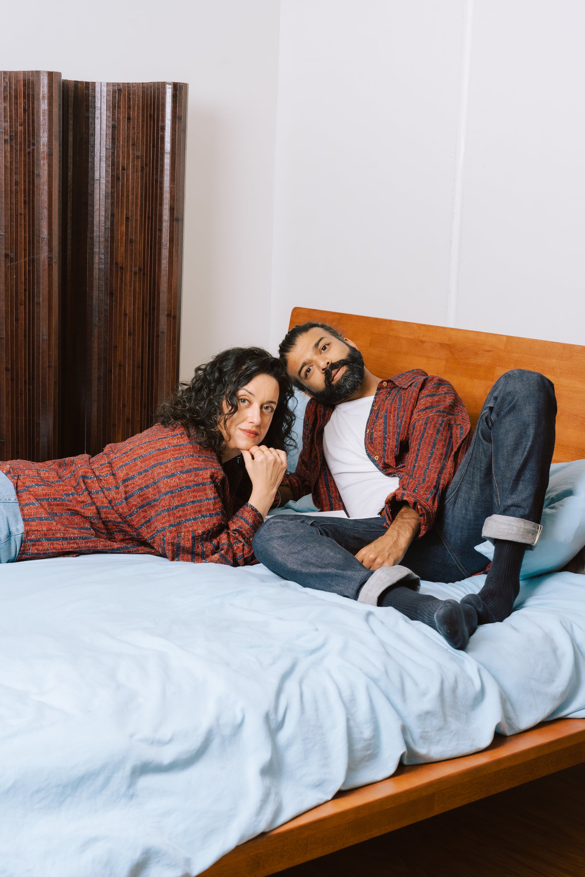 Models wearing the unisex Studio Red Zulfi Overshirt made from sustainable Ajrak fabric, photographed in natural light.
